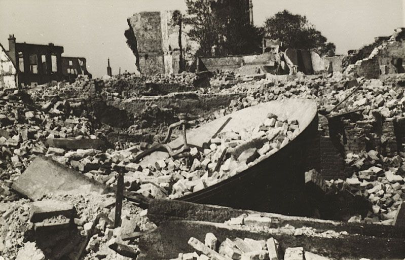 De uit de toren van de Abdij gevallen grote klok in de puinhopen in het centrum van Middelburg, mei 1940. (Zeeuws Archief)